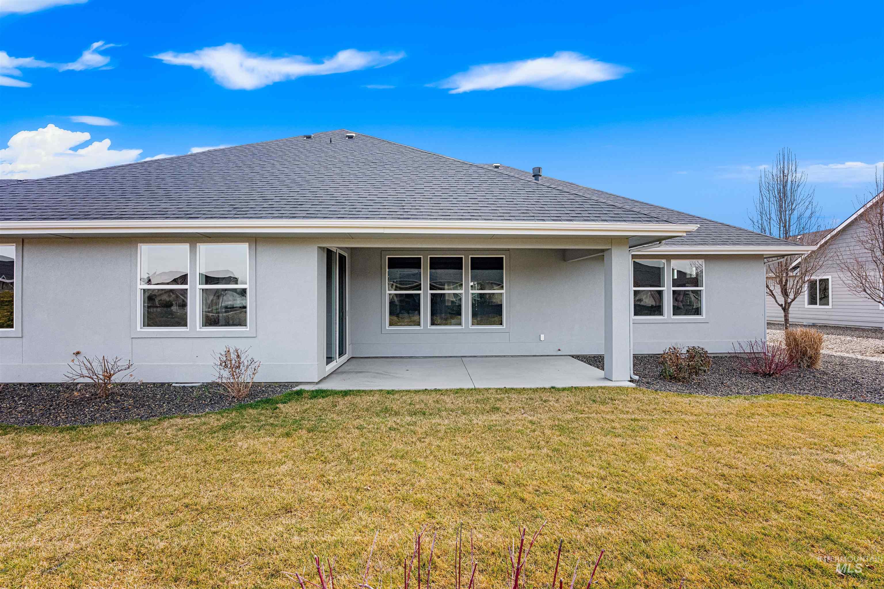 8078 Tandy Cv Street Middleton, ID 83644 - Photo 36 of 40 Back of property featuring stucco siding, a patio, a shingled roof, and a lawn