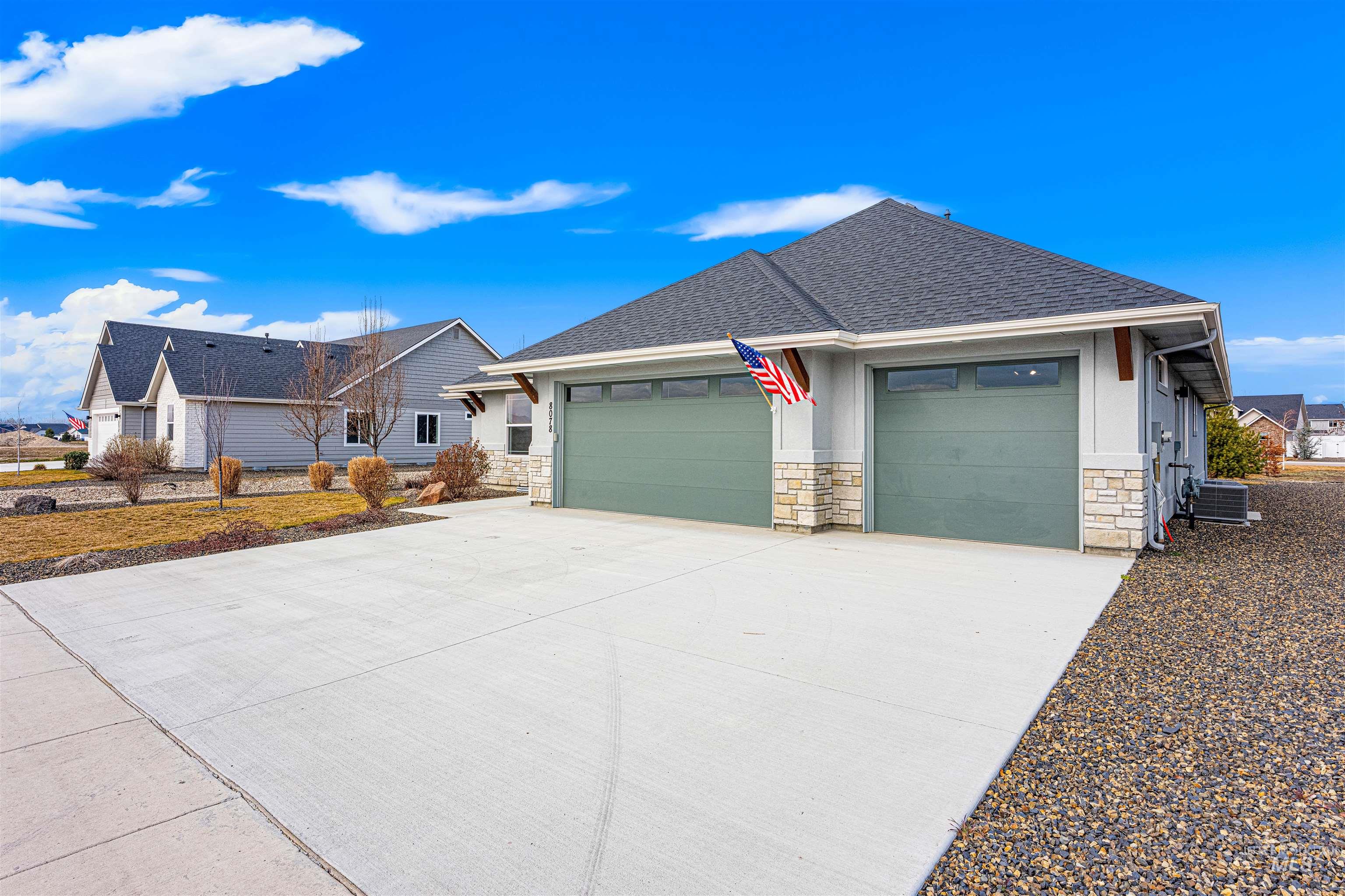 8078 Tandy Cv Street Middleton, ID 83644 - Photo 39 of 40 View of front facade featuring stone siding, a shingled roof, concrete driveway, and a garage