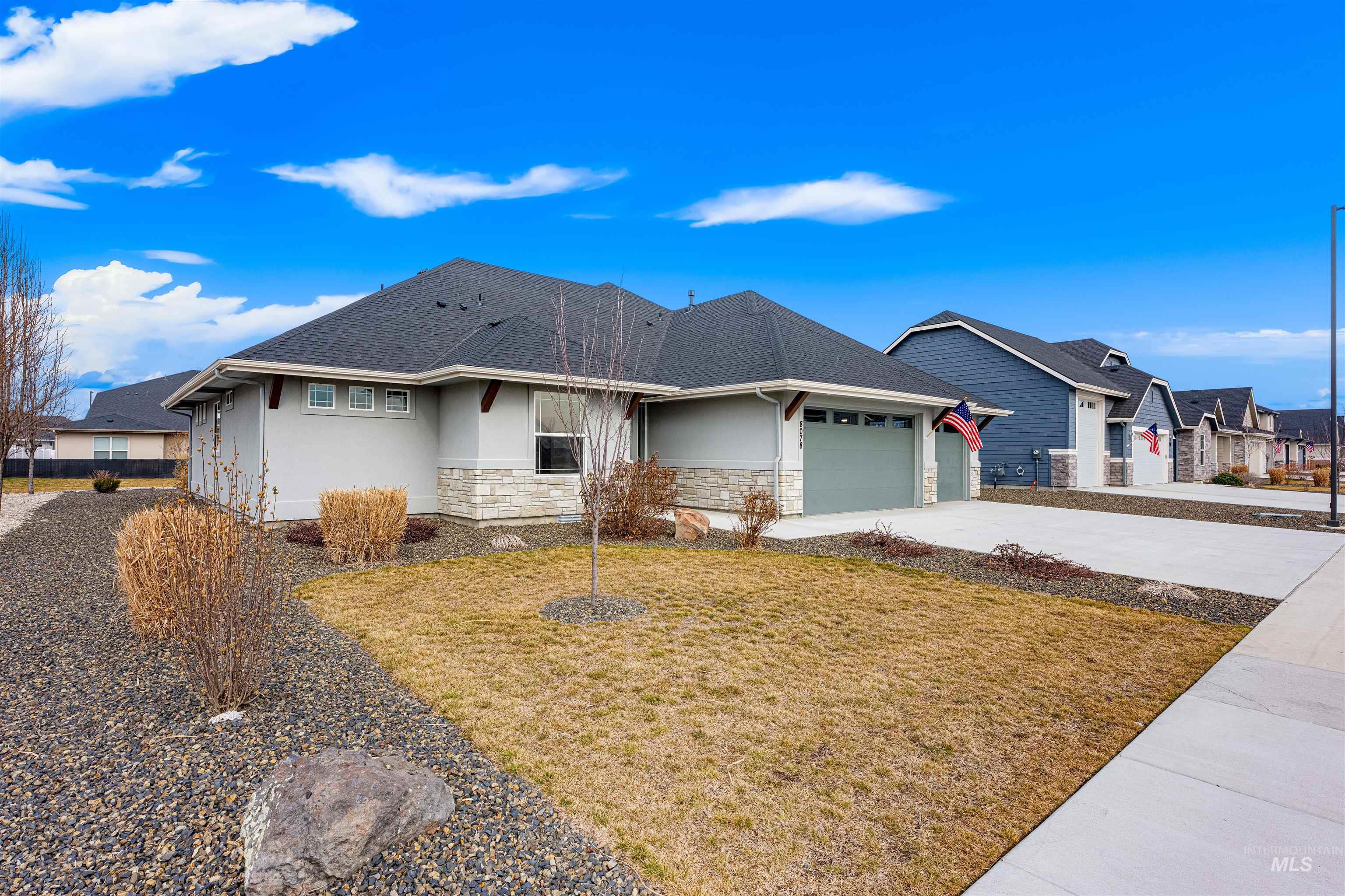 8078 Tandy Cv Street Middleton, ID 83644 - Photo 40 of 40 View of front of home featuring stucco siding, a front lawn, stone siding, driveway, and a garage