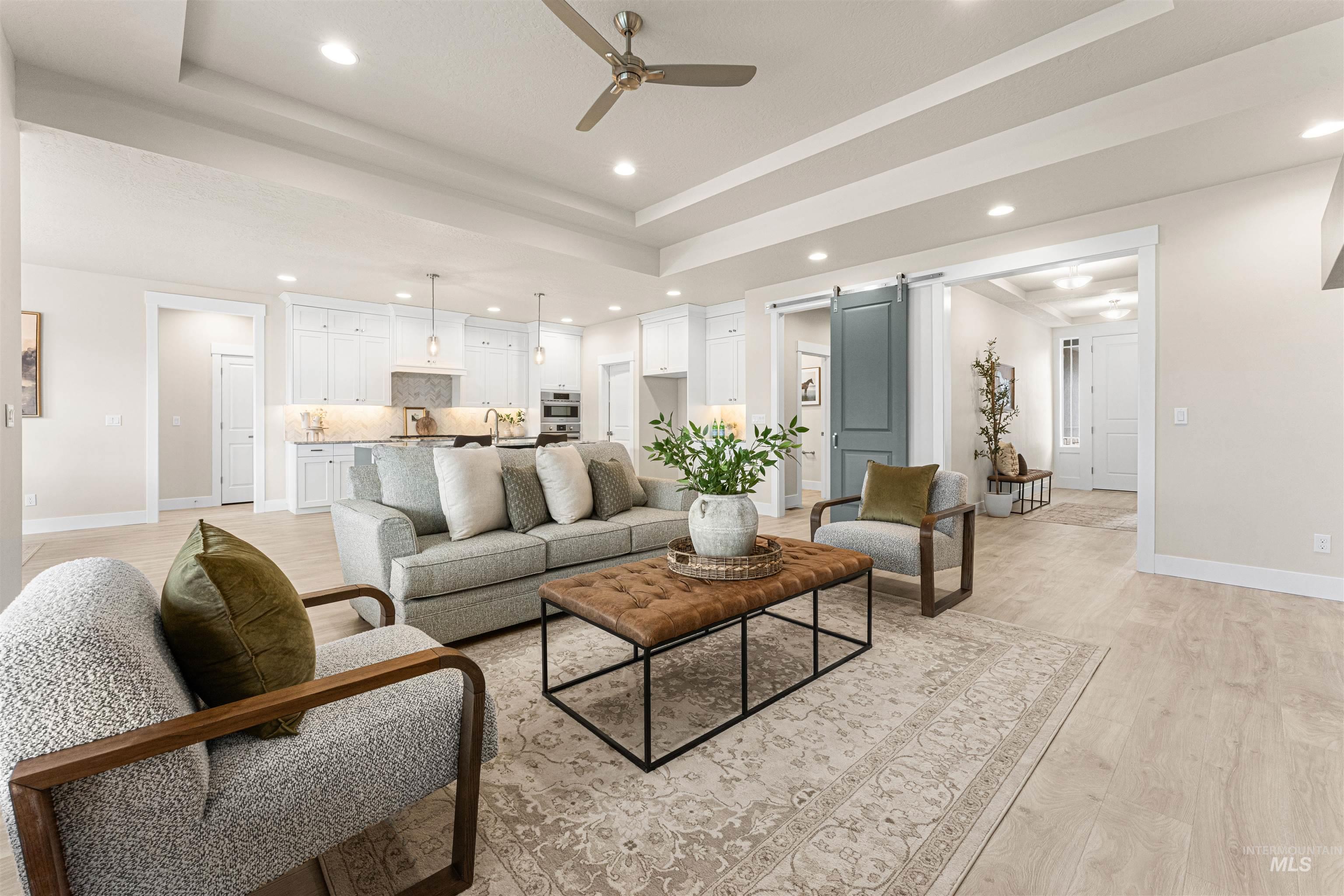 8078 Tandy Cv Street Middleton, ID 83644 - Photo 7 of 40 Living room featuring a barn door, light wood-type flooring, a raised ceiling, a ceiling fan, and recessed lighting