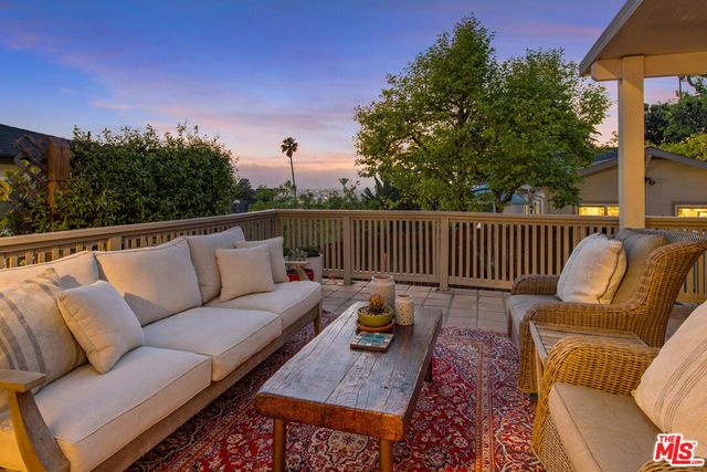 a roof deck with couches and wooden floor