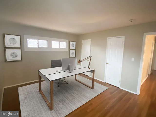 a view of a workspace with furniture and wooden floor