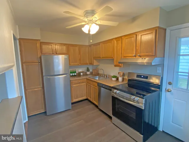 a kitchen with a refrigerator sink and cabinets
