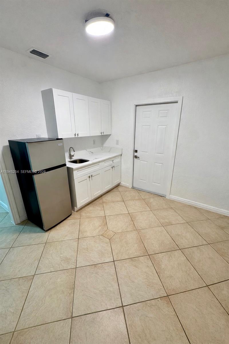 6541 West 11th Court, Unit 1 Hialeah, FL 33012 - Photo 2 of 6 a kitchen with a cabinets and a stove top oven