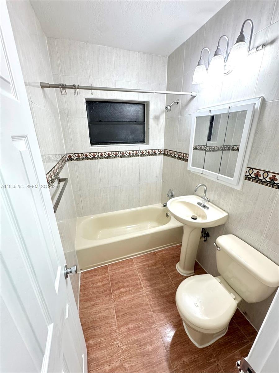 6541 West 11th Court, Unit 1 Hialeah, FL 33012 - Photo 5 of 6 a bathroom with a sink toilet a mirror and bathtub