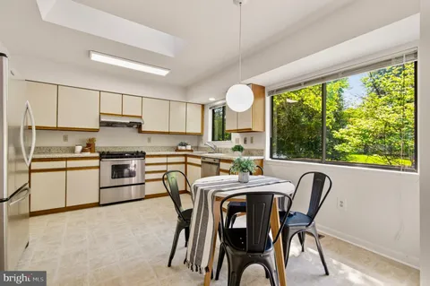 a kitchen with a stove a sink and white cabinets