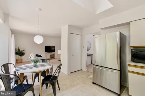 a kitchen with stainless steel appliances granite countertop a stove a refrigerator a kitchen island a table and chairs