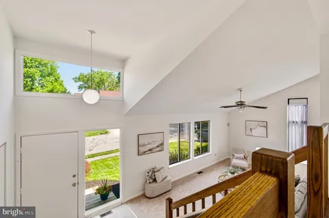 a living room with furniture a flat screen tv and a large window