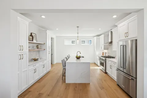 a kitchen with cabinets and wooden floor