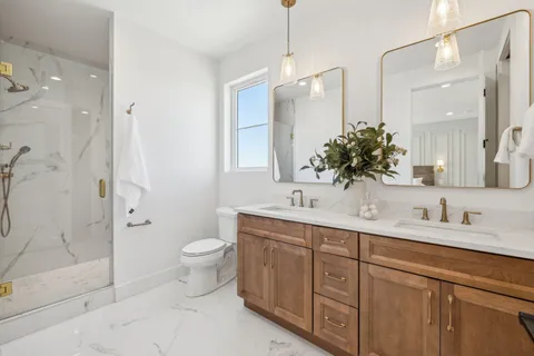 a bathroom with a double vanity sink mirror and toilet