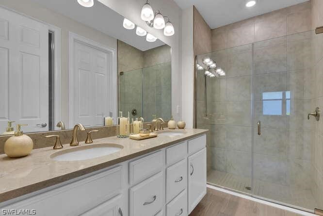1064 Tranquil Brook Drive Naples, FL 34114 - Photo 17 of 28 a bathroom with double vanity sinks a shower a vanity and a mirror