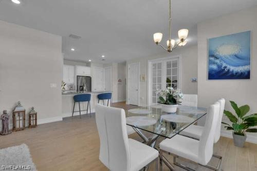 1064 Tranquil Brook Drive Naples, FL 34114 - Photo 8 of 28 a view of a dining room with furniture and chandelier