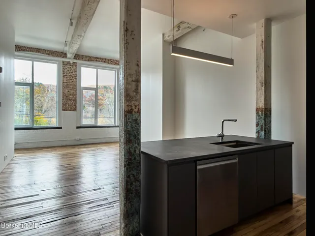 a kitchen with granite countertop a sink and wooden floor
