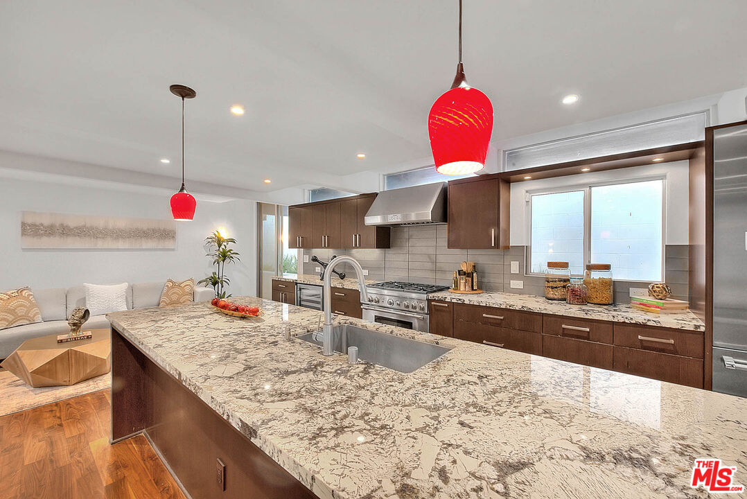 3804 Duray Place Los Angeles, CA 90008 - Photo 16 of 73 a kitchen with stainless steel appliances kitchen island granite countertop a sink and white cabinets