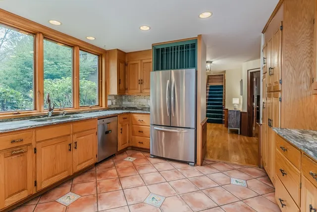 a kitchen with granite countertop a refrigerator and a sink