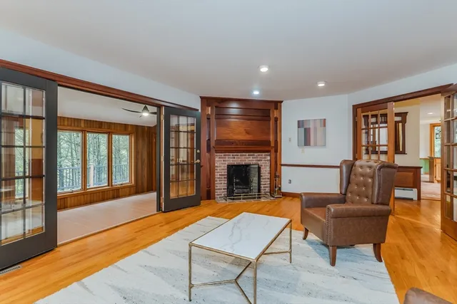 a living room with furniture a fireplace and a floor to ceiling window