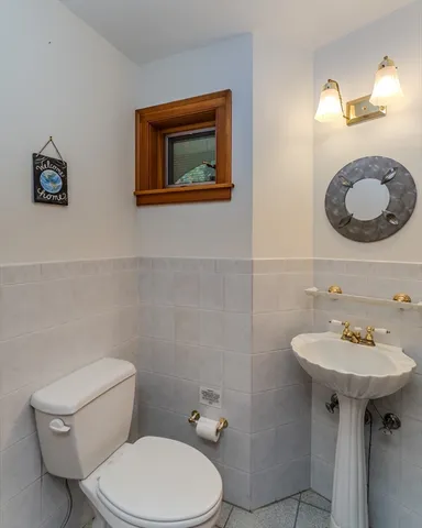 a bathroom with a toilet sink and mirror