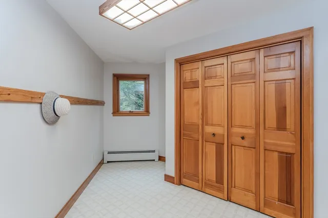 a view of empty room with window and wooden floor