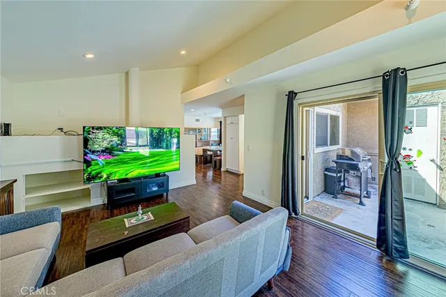 a living room with furniture and a dining table with garden view
