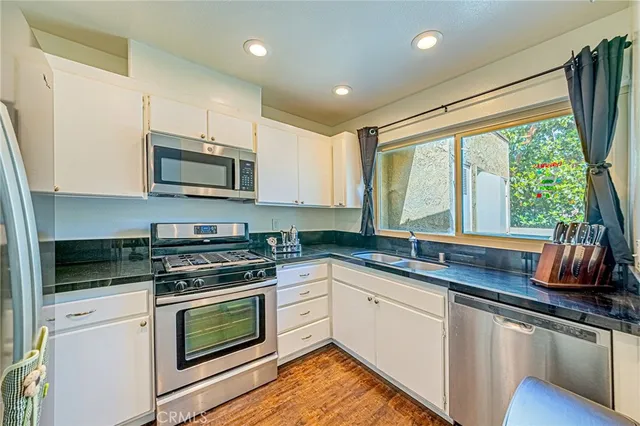 a kitchen with stainless steel appliances a stove sink microwave and cabinets