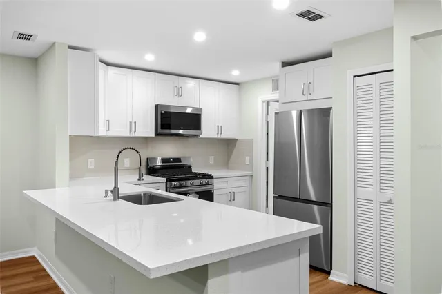 a kitchen with stainless steel appliances a refrigerator sink and microwave