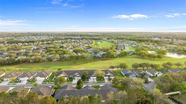 an aerial view of a city with lots of residential buildings ocean and mountain view in back