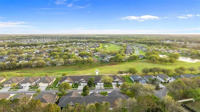 an aerial view of a city with lots of residential buildings ocean and mountain view in back