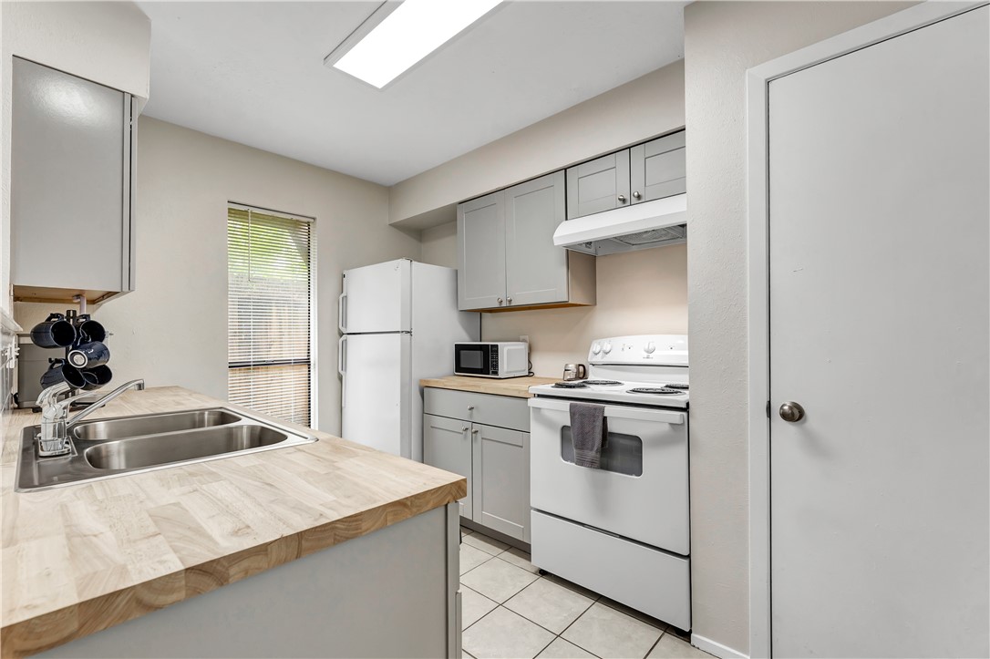 1516 Hawk Tree Drive, Unit C College Station, TX 77845 - Photo 8 of 15 a kitchen that has a lot of white cabinets and stainless steel appliances