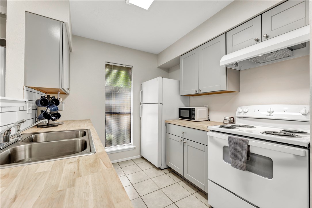 1516 Hawk Tree Drive, Unit C College Station, TX 77845 - Photo 9 of 15 a kitchen with stainless steel appliances granite countertop a sink and a refrigerator