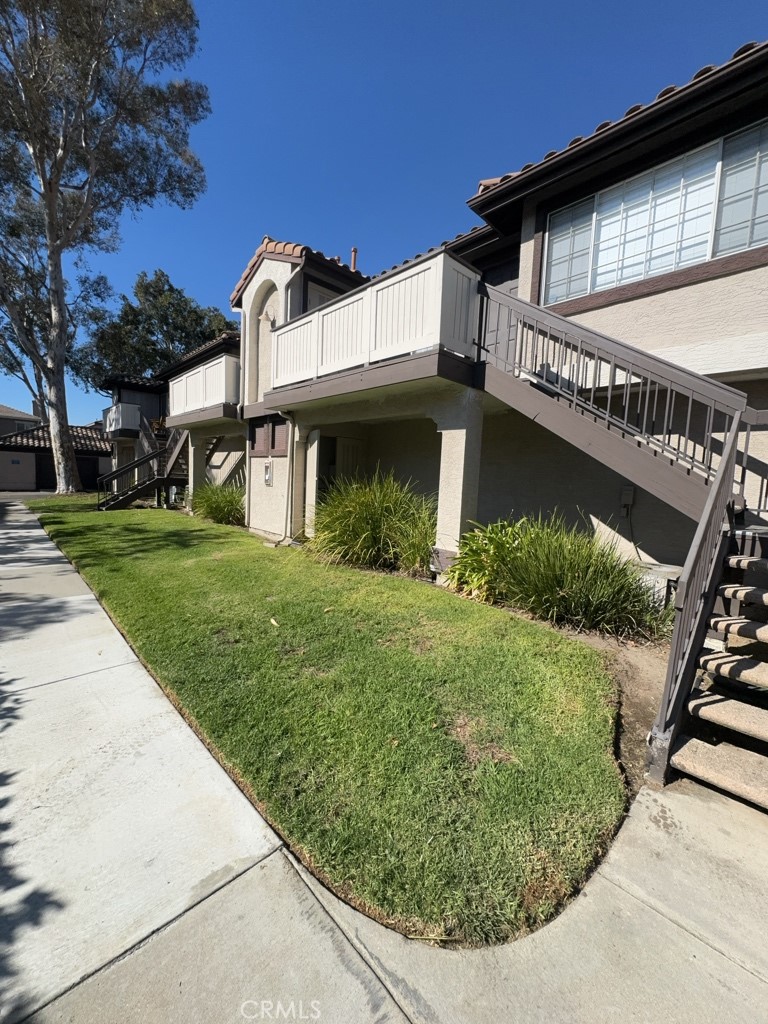12584 Atwood Court, Unit 1023 Rancho Cucamonga, CA 91739 - Photo 2 of 19 a view of a white house with a big yard and potted plants