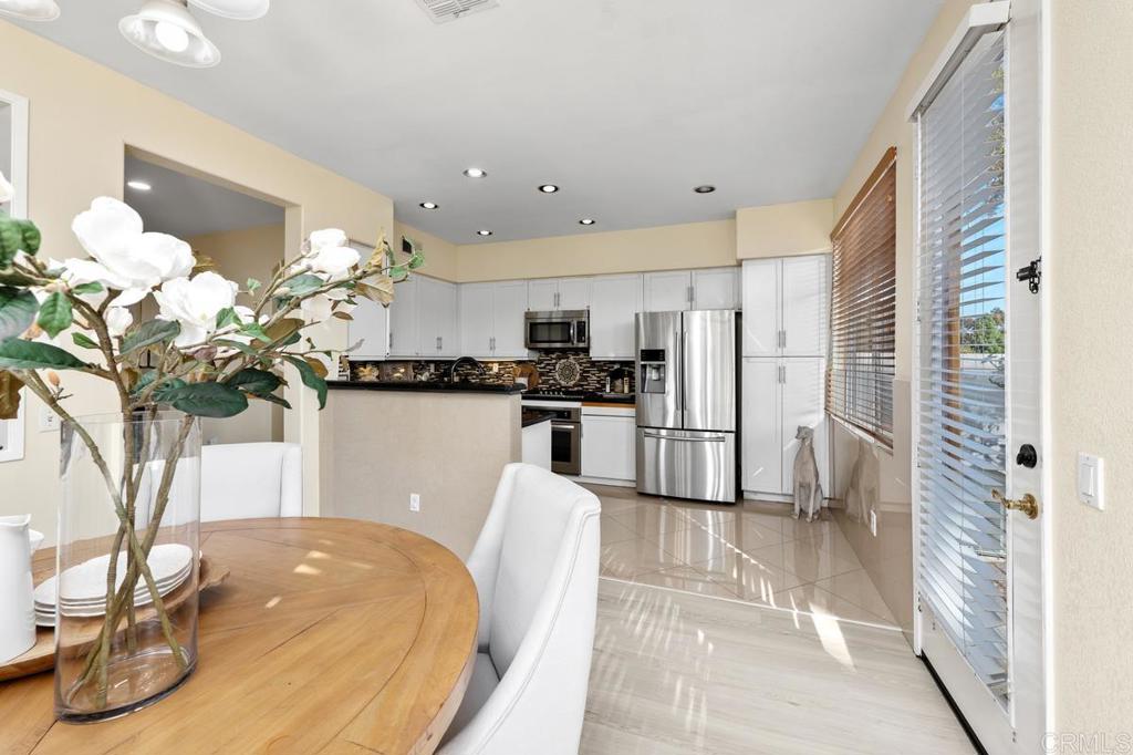 12490 Heatherton Court, Unit 8 San Diego, CA 92128 - Photo 11 of 30 a kitchen with stainless steel appliances granite countertop a refrigerator a sink a stove a dining table and chairs