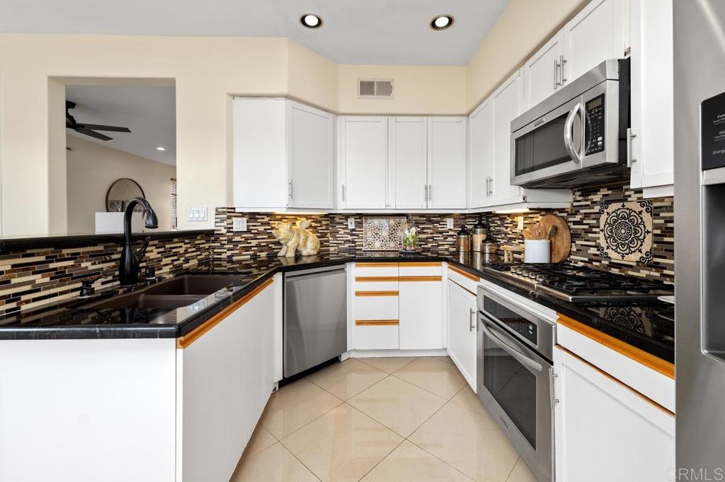 12490 Heatherton Court, Unit 8 San Diego, CA 92128 - Photo 13 of 30 a kitchen with granite countertop a sink and a stove top oven