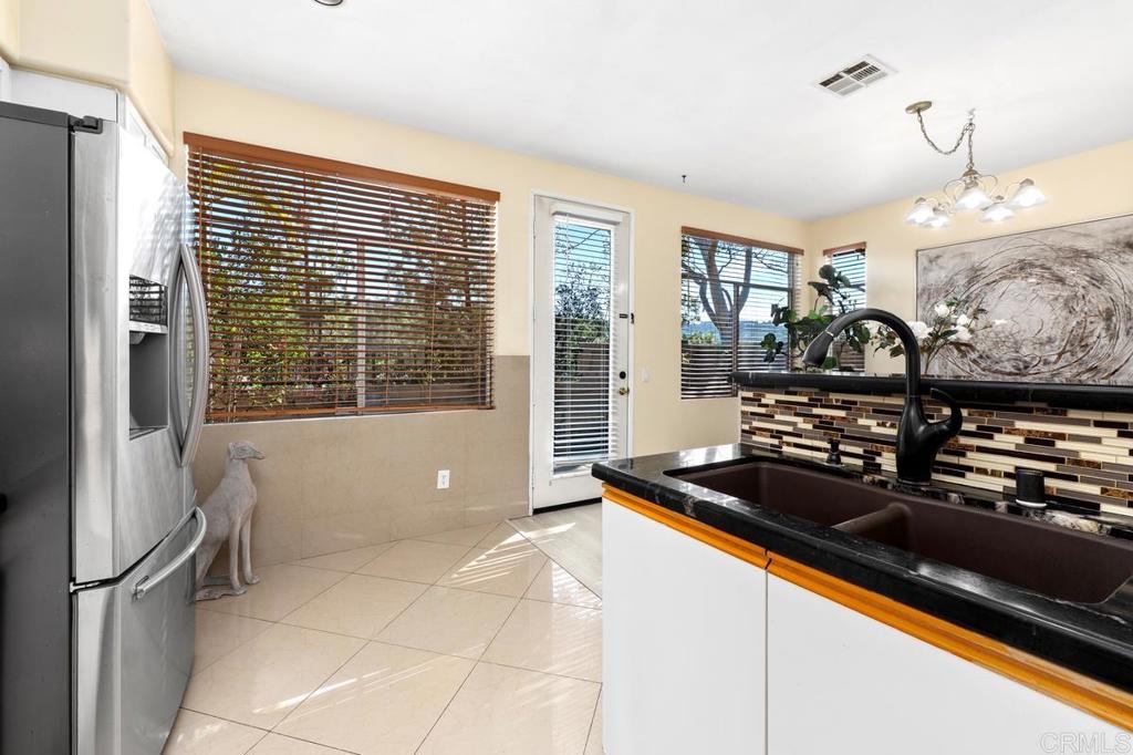 12490 Heatherton Court, Unit 8 San Diego, CA 92128 - Photo 14 of 30 a kitchen with stainless steel appliances granite countertop a sink stove and refrigerator