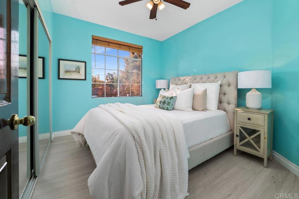 12490 Heatherton Court, Unit 8 San Diego, CA 92128 - Photo 29 of 30 a bedroom with a bed and a chandelier