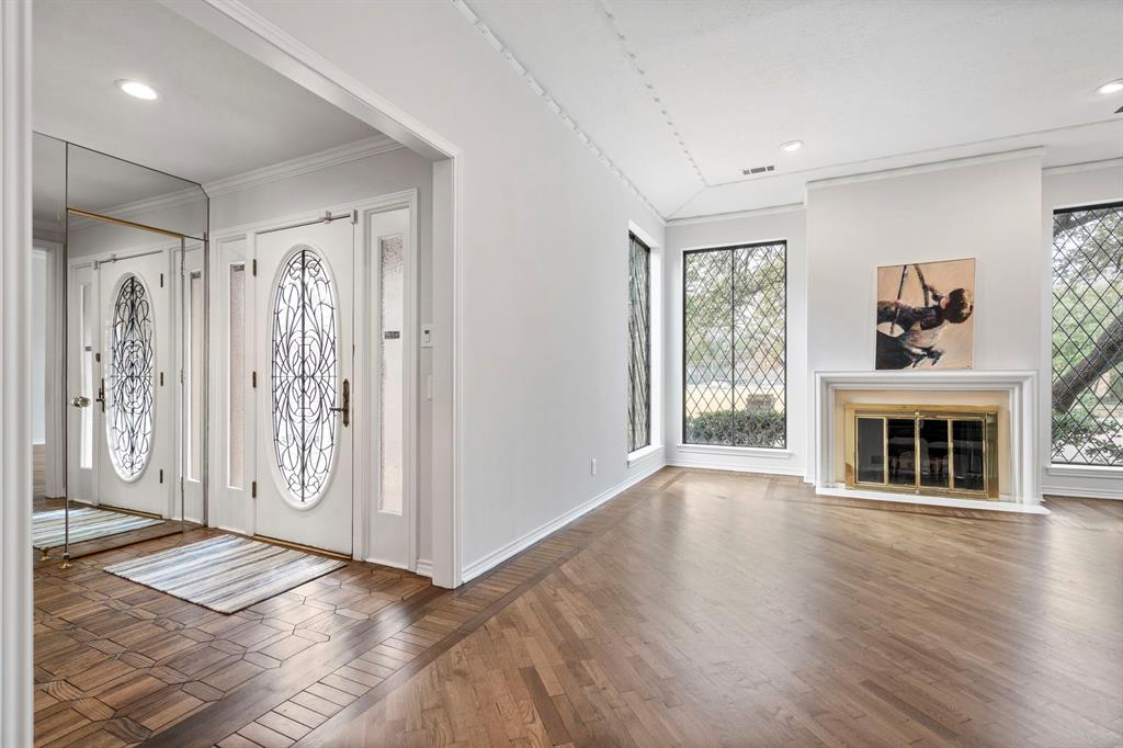 12616 Sunlight Drive Dallas, TX 75230 - Photo 3 of 40 a view of a livingroom with wooden floor fireplace and windows