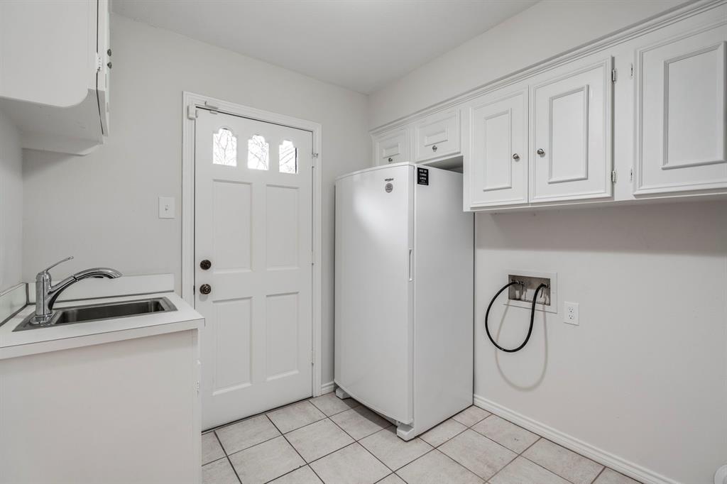 12616 Sunlight Drive Dallas, TX 75230 - Photo 33 of 40 a bathroom with a granite countertop sink and a refrigerator