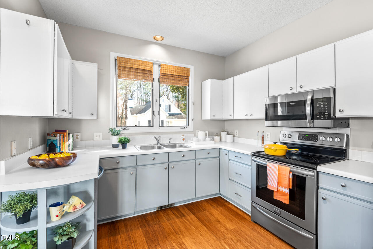 125 Legacy Lane Durham, NC 27713 - Photo 9 of 37 a kitchen with stainless steel appliances granite countertop a stove a sink and a microwave