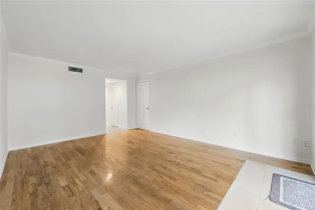 a view of empty room with wooden floor