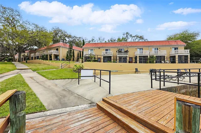 a view of a house with wooden deck and furniture