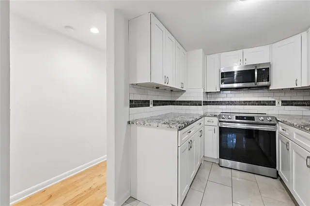 a kitchen with stainless steel appliances granite countertop a stove and a microwave