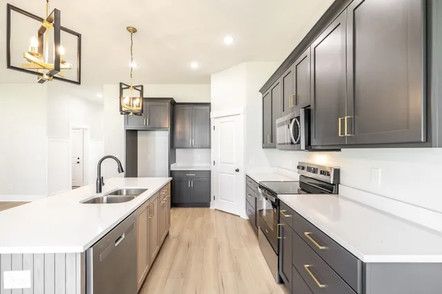 a kitchen with stainless steel appliances a sink stove and refrigerator