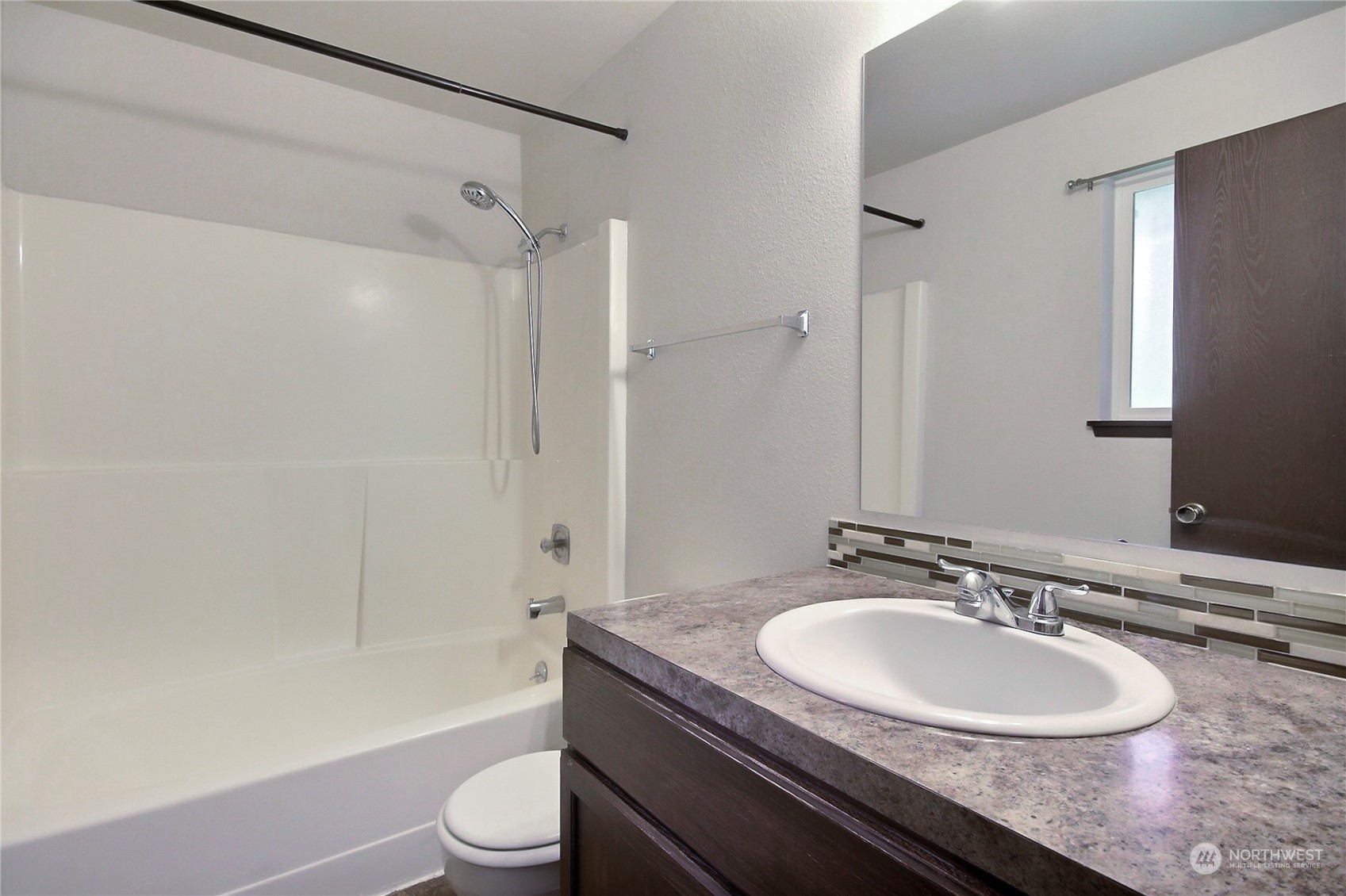 818 Haskell Street DuPont, WA 98327 - Photo 11 of 26 a bathroom with a granite countertop sink toilet a mirror and a bathtub