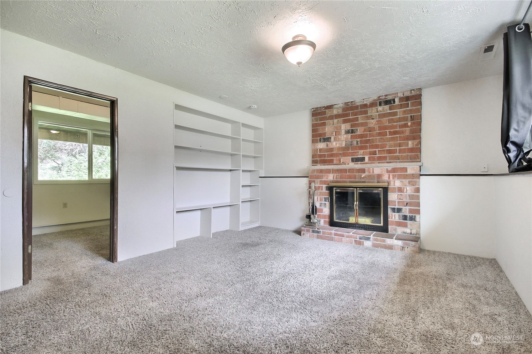 818 Haskell Street DuPont, WA 98327 - Photo 16 of 26 an empty room with a fireplace and cabinet