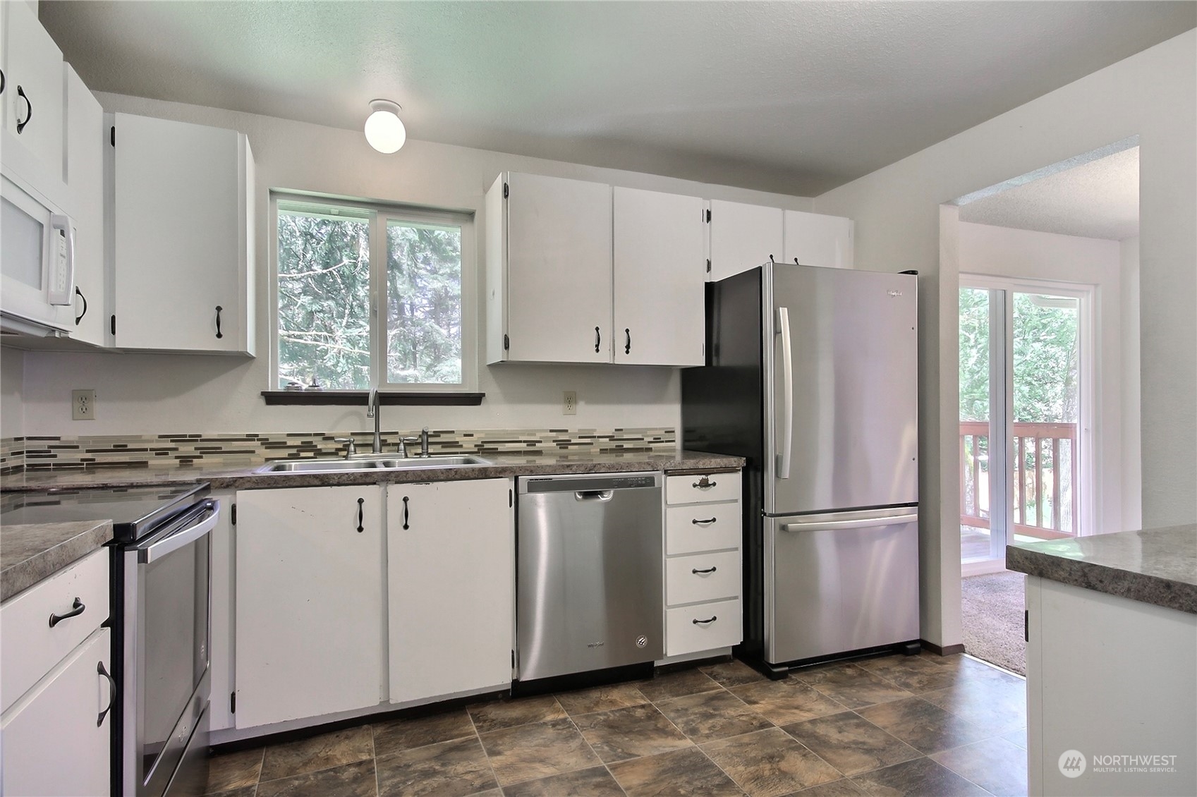 818 Haskell Street DuPont, WA 98327 - Photo 5 of 26 a kitchen with granite countertop white cabinets white appliances a sink and a window