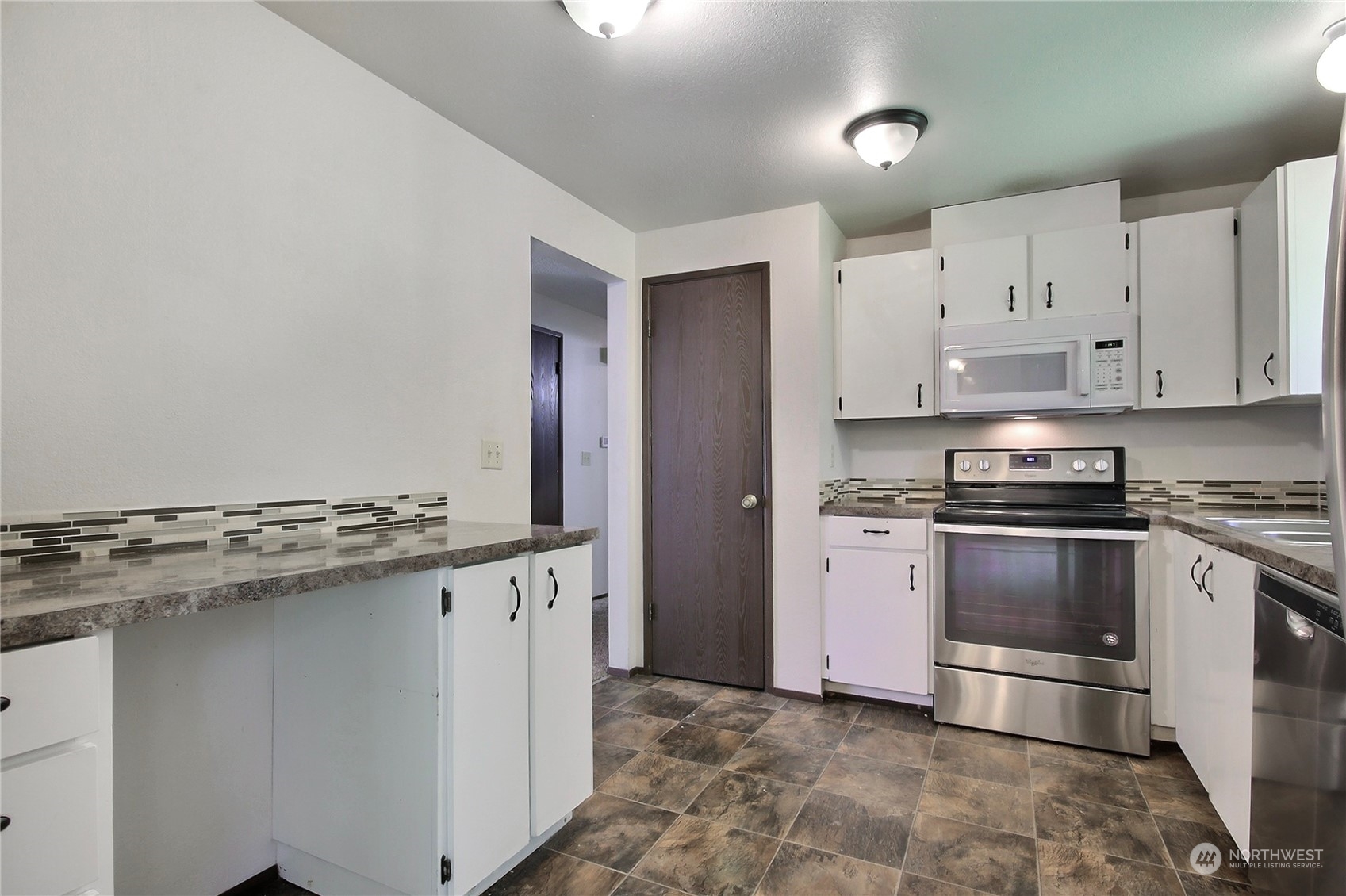 818 Haskell Street DuPont, WA 98327 - Photo 6 of 26 a kitchen with granite countertop a stove and a refrigerator