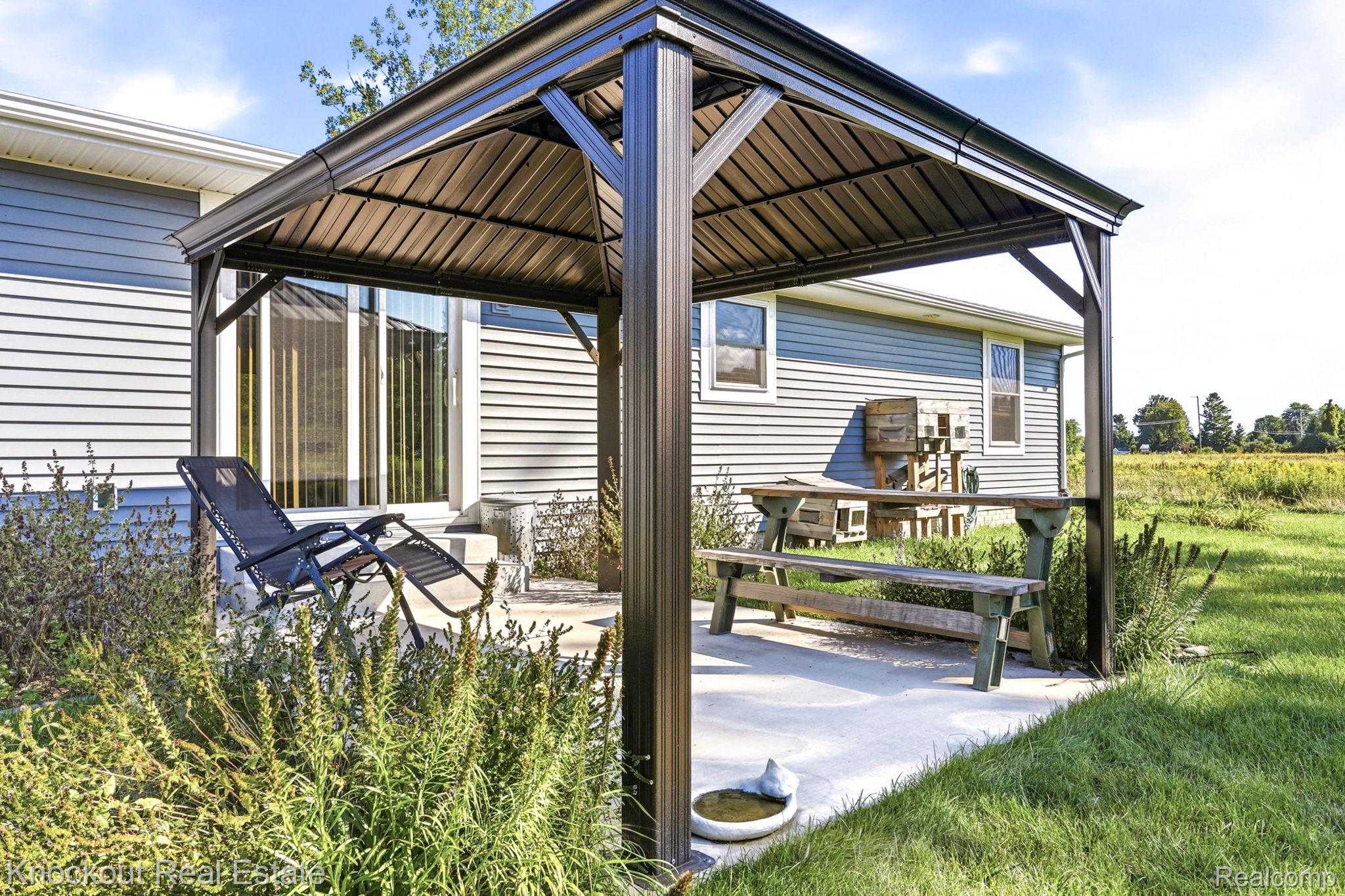 5727 Mackinaw Road Saginaw, MI 48604 - Photo 38 of 60 Patio area featuring a permanent gazebo structure, concrete hardscaping, and siding exterior