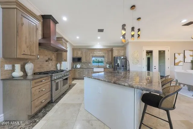 a kitchen with granite countertop a counter space dining table and stainless steel appliances