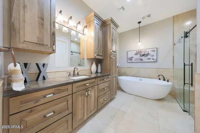 a white bath tub sitting next to a white sink and vanity