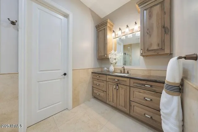 an empty room with a chandelier fan and windows