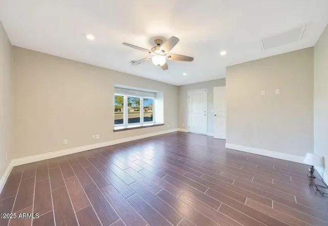 a view of a livingroom with wooden floor and a ceiling fan